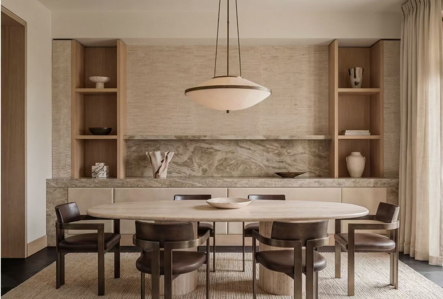 Salle à manger du Projet Rivage avec table ovale en bois et suspension albâtre