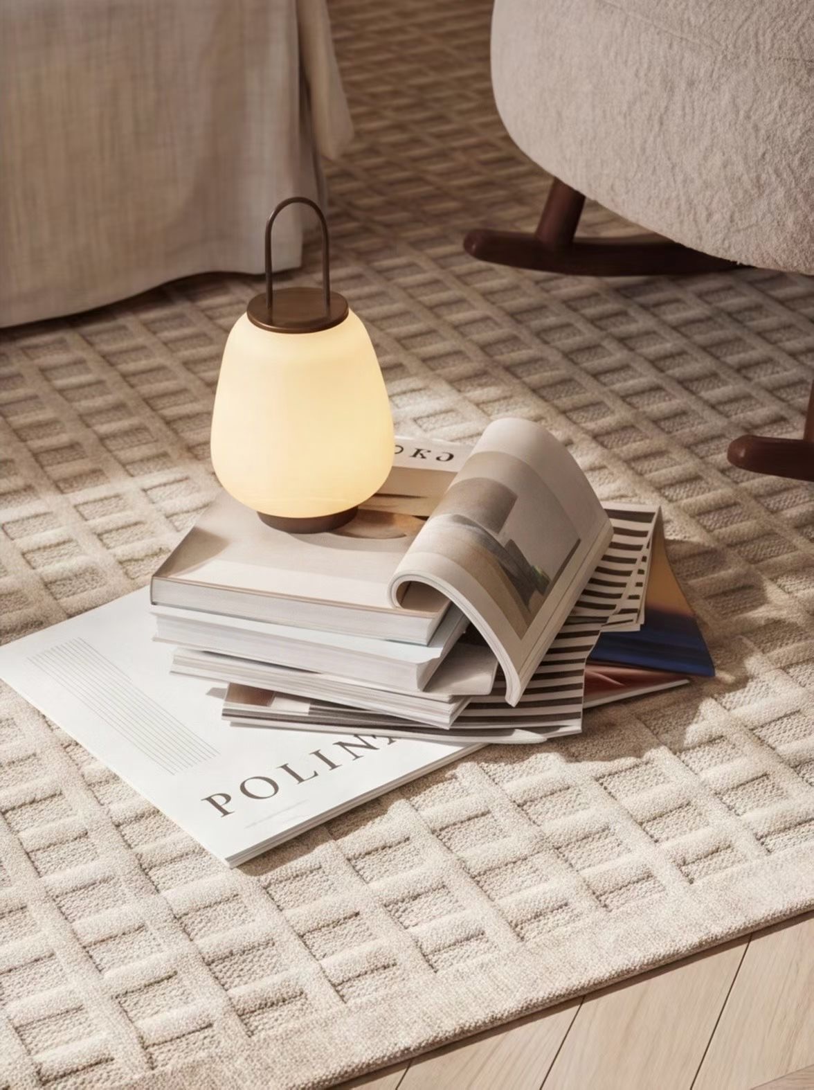 Nature morte Projet Lumière — lampe nomade sur pile de revues